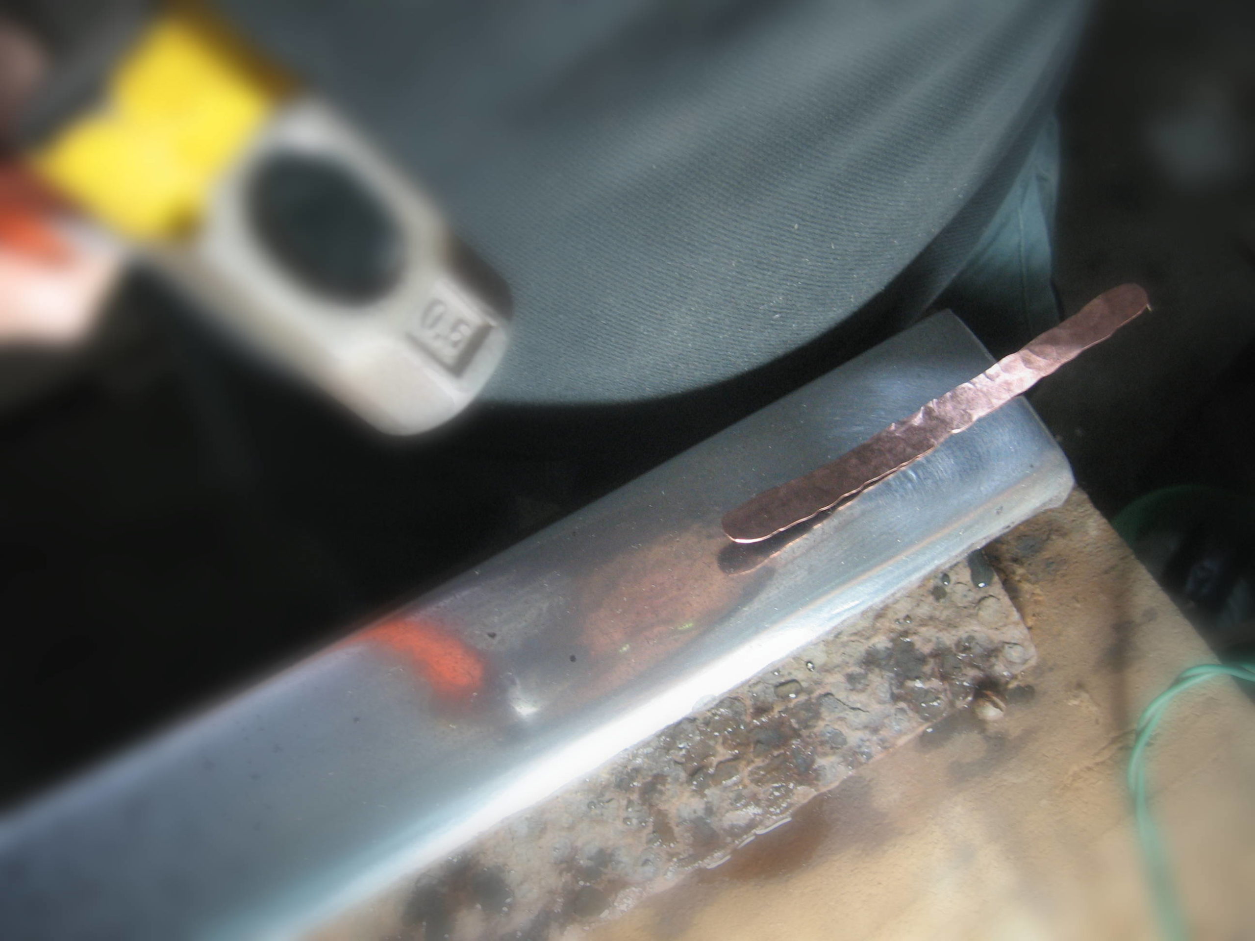 Foto de bateção de um marcador de cobre na bigorna